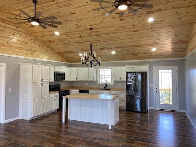 kitchen with a sink, ceiling fan with notable chandelier, black appliances, and wood ceiling