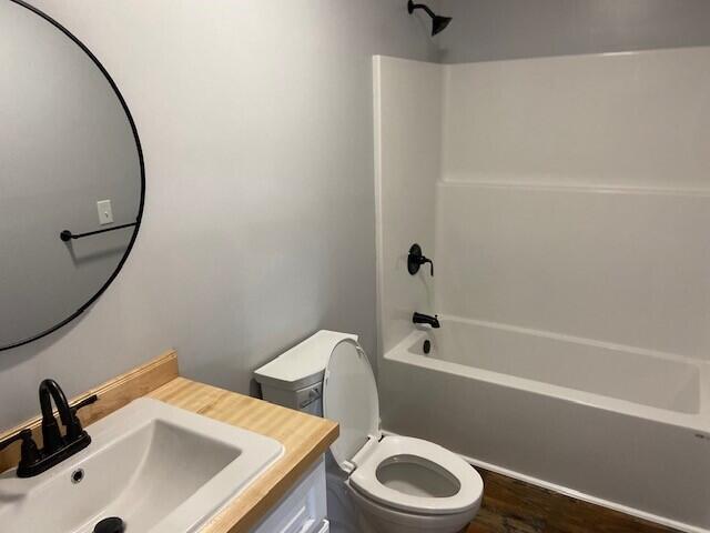 full bathroom featuring toilet, vanity, wood finished floors, and shower / bathtub combination