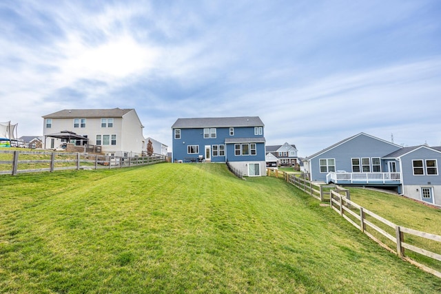 back of property featuring a fenced backyard, a residential view, and a lawn
