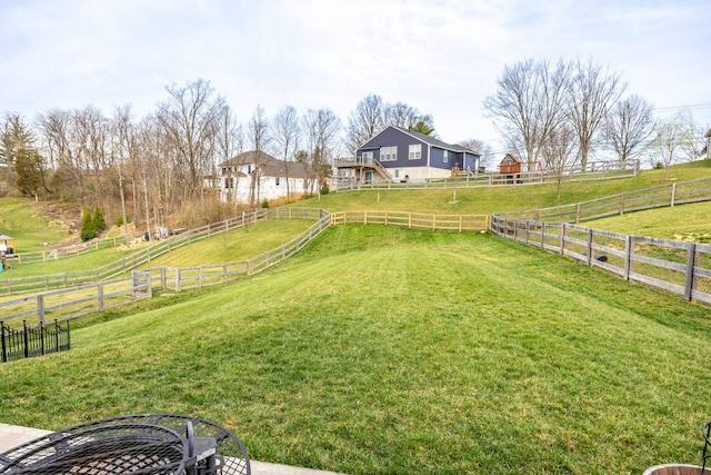 view of yard with a rural view, fence, and an outdoor structure