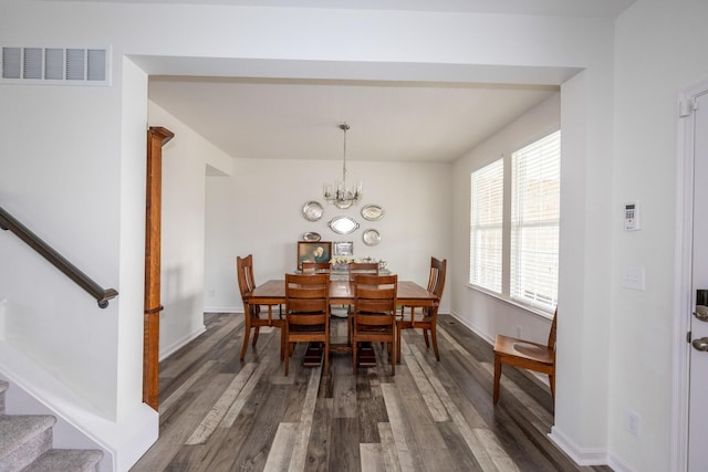 dining space featuring visible vents, baseboards, an inviting chandelier, dark wood-style floors, and stairway