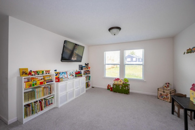 recreation room with baseboards and carpet