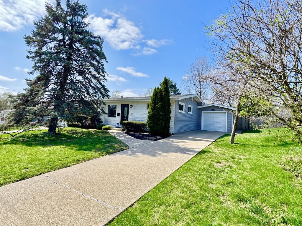 single story home featuring concrete driveway, fence, and a front lawn