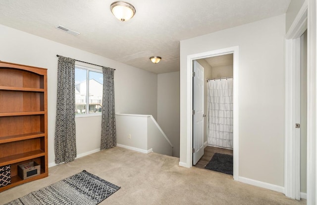 unfurnished bedroom with light carpet, visible vents, and baseboards