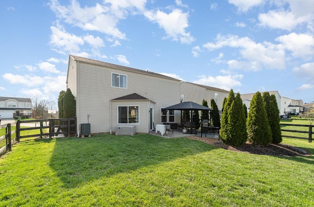 back of property with a patio, a yard, central AC unit, a fenced backyard, and a gazebo