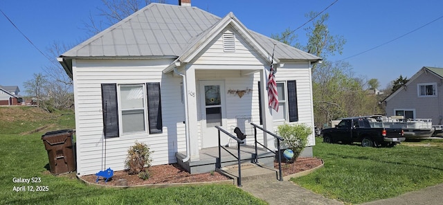 view of front of home with a front yard and metal roof