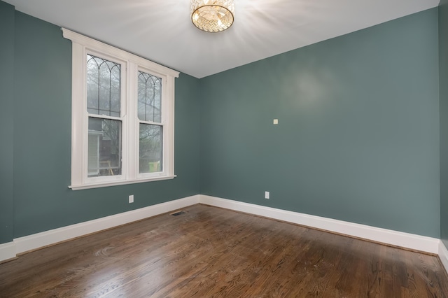 224 Wallace Ave, Covington, KY 41014 - empty room with a chandelier, dark wood finished floors, visible vents, and baseboards