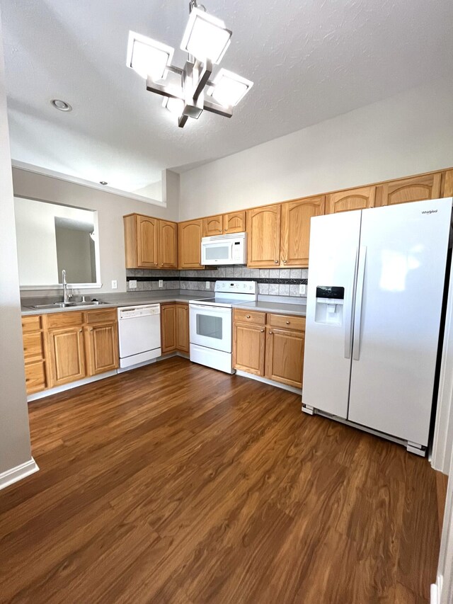 kitchen featuring dark wood-type flooring, white appliances, light countertops, and a sink