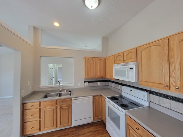 kitchen with white appliances, tasteful backsplash, light brown cabinetry, light countertops, and a sink