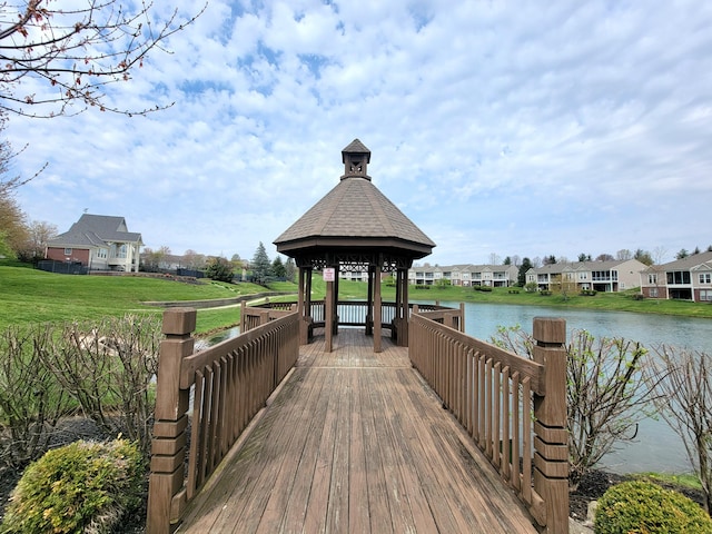 dock area with a water view, a gazebo, a residential view, and a lawn