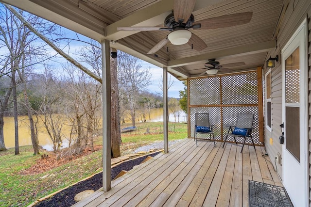 wooden terrace featuring ceiling fan and a water view