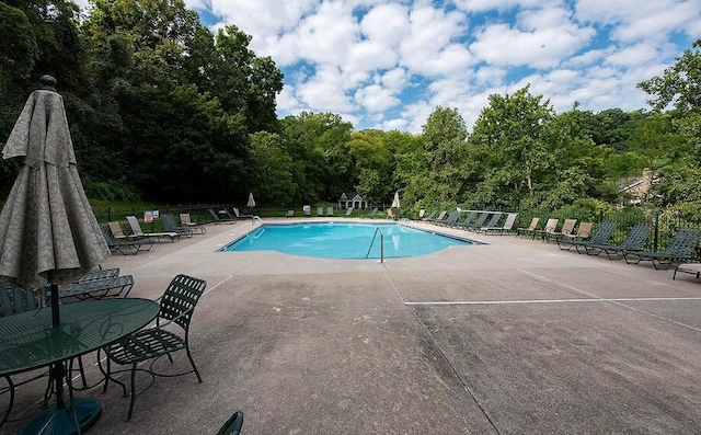pool with a patio and fence