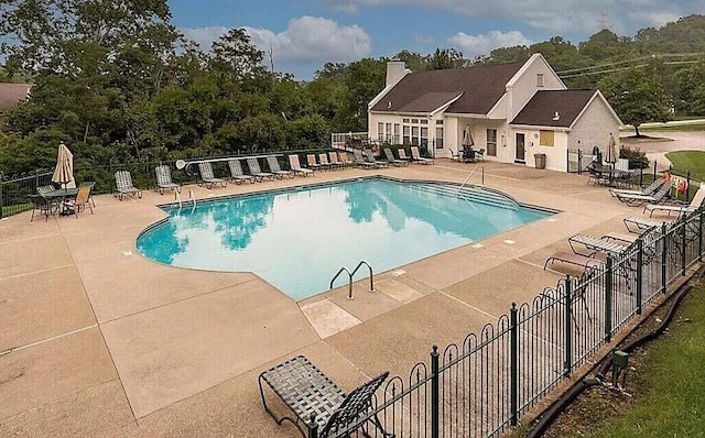 pool featuring fence and a patio