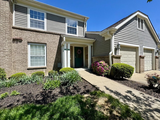 traditional home with concrete driveway and brick siding