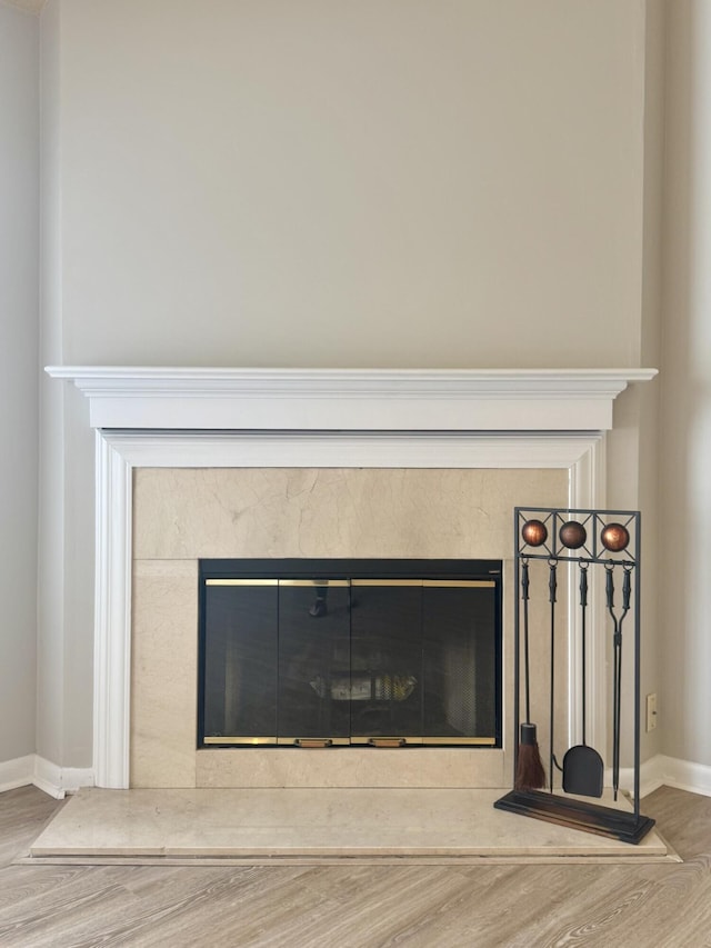 interior details with baseboards, wood finished floors, and a fireplace