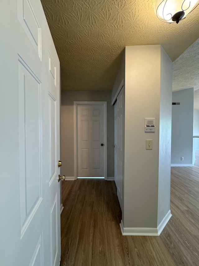 hallway with baseboards and wood finished floors
