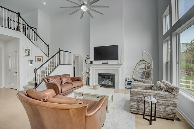9956 Meadow Glen Dr, Independence, KY 41051 - living area with ceiling fan, a towering ceiling, stairway, a brick fireplace, and baseboards