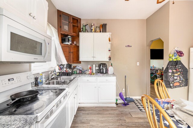 25 High St, Newport, KY 41071 - kitchen with arched walkways, a sink, light wood-type flooring, white appliances, and white cabinetry