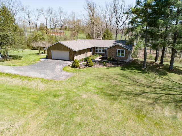 view of front of house with a garage, driveway, a front lawn, and stone siding
