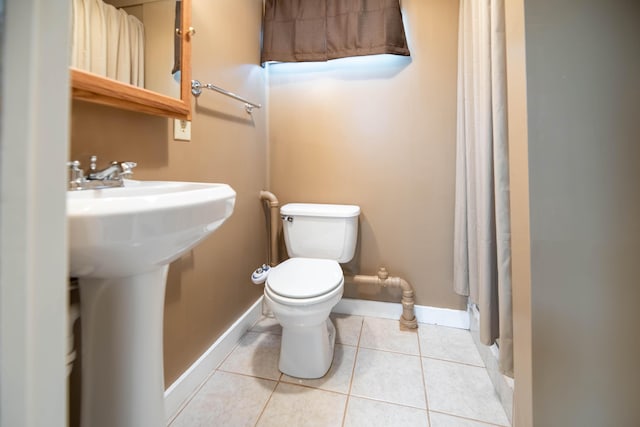 full bathroom with a sink, tile patterned flooring, toilet, baseboards, and a shower with curtain