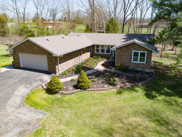 ranch-style house featuring a garage, aphalt driveway, stone siding, a front yard, and a shingled roof