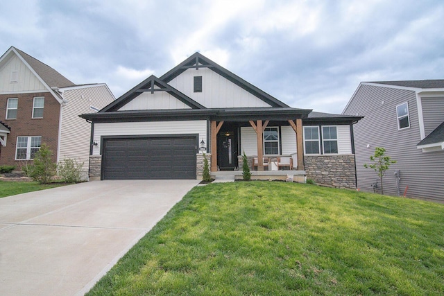 craftsman-style home with a garage, covered porch, stone siding, a front lawn, and concrete driveway