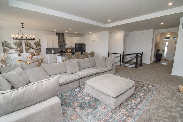 living area with recessed lighting, arched walkways, a chandelier, and light carpet