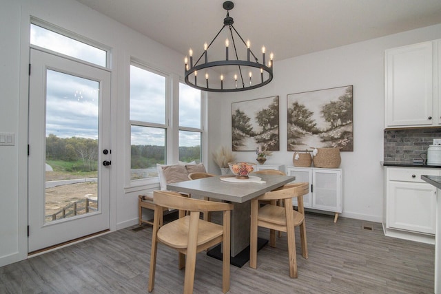 dining area featuring light wood-style floors, an inviting chandelier, and baseboards