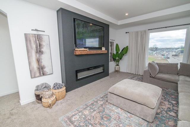 living area with a glass covered fireplace, recessed lighting, carpet, and baseboards