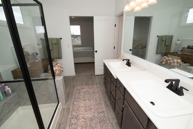bathroom with a shower stall, ensuite bath, a sink, and wood finished floors