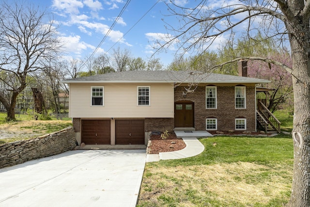 raised ranch with a front yard, brick siding, driveway, a chimney, and an attached garage