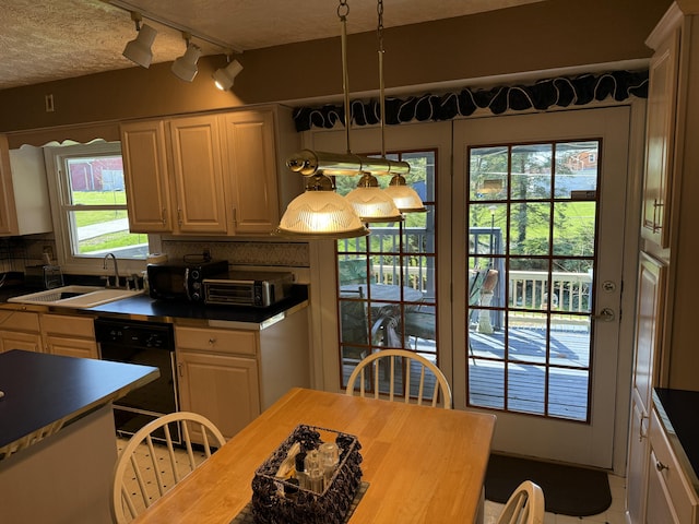 kitchen featuring a sink, tasteful backsplash, black appliances, and dark countertops