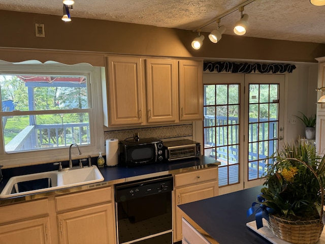 kitchen featuring a textured ceiling, a sink, rail lighting, and black appliances