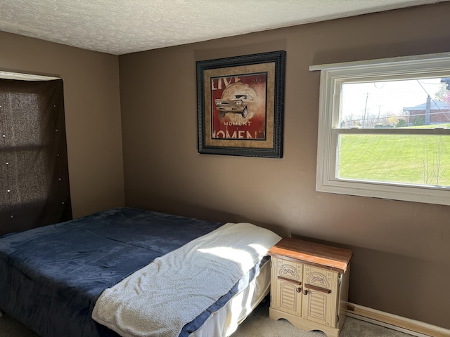 bedroom featuring light carpet and a textured ceiling