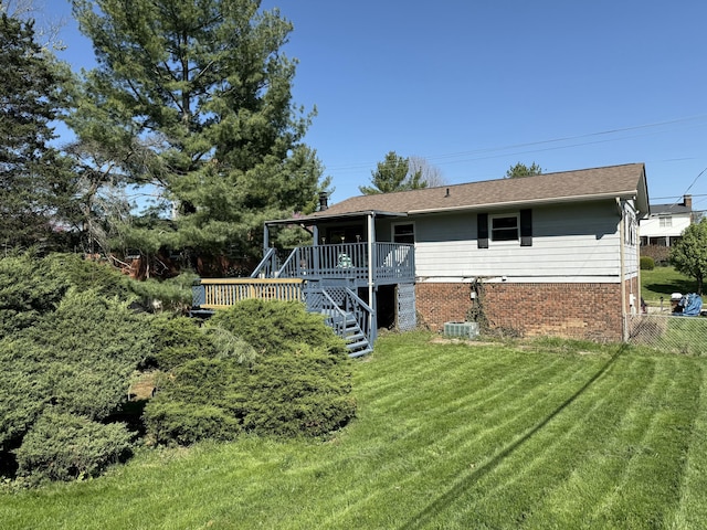 single story home with a front yard, brick siding, stairs, a wooden deck, and fence