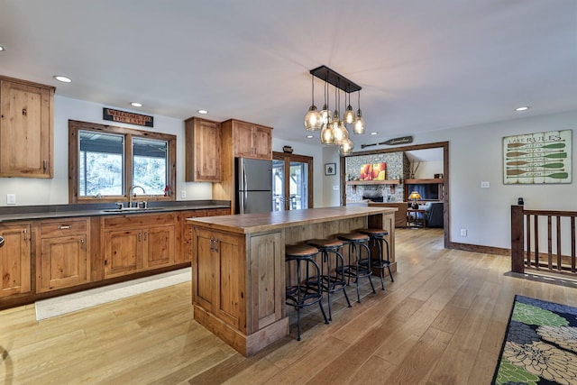 445 Elk Lake Resort Rd Unit 947-948, Owenton, KY 40359 - kitchen with freestanding refrigerator, dark countertops, a breakfast bar area, light wood-style floors, and a center island