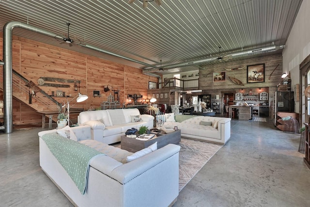 living area featuring concrete floors and wood walls