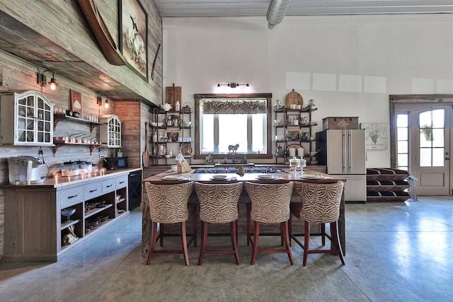 dining area featuring concrete flooring and a high ceiling