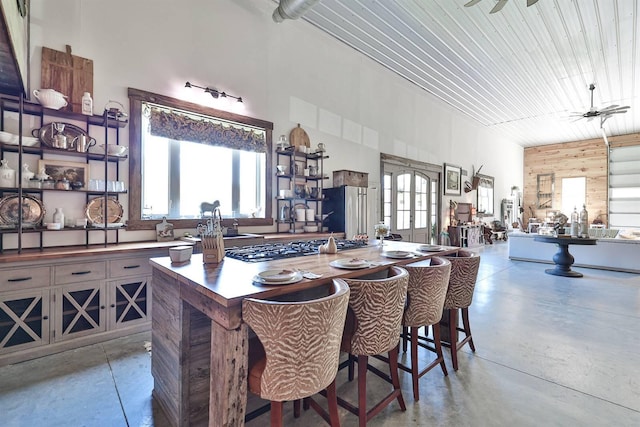 dining space featuring concrete flooring, plenty of natural light, and ceiling fan