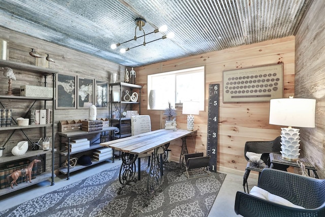 office space featuring wood walls, a notable chandelier, and finished concrete floors