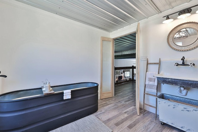 interior space featuring baseboards, wood finished floors, and ornamental molding