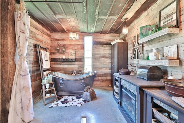 interior space with wood ceiling, a soaking tub, wooden walls, and concrete flooring