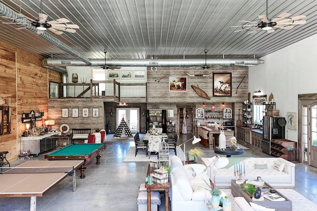 rec room featuring pool table, concrete flooring, a ceiling fan, and wooden walls