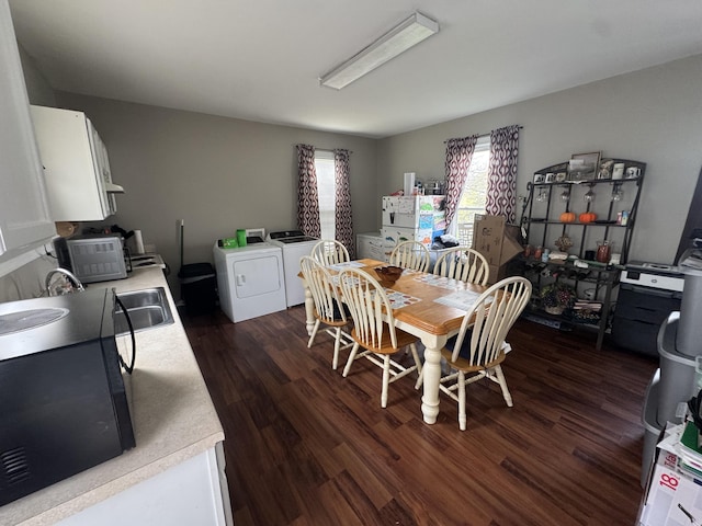 dining room featuring washing machine and clothes dryer and dark wood finished floors