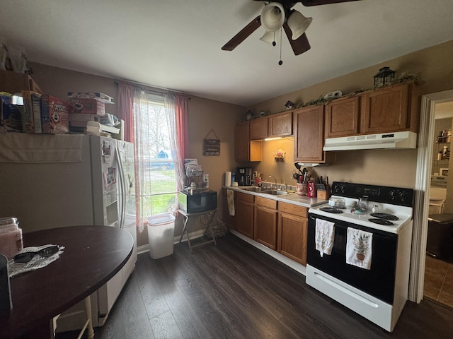 kitchen featuring a ceiling fan, a sink, brown cabinets, white appliances, and under cabinet range hood