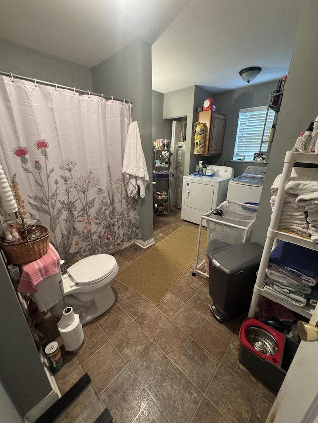 bathroom featuring vanity, washing machine and clothes dryer, toilet, and tile patterned flooring