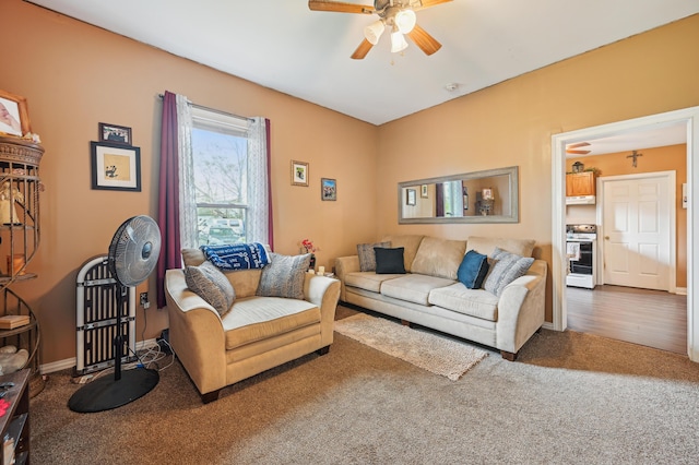 living area featuring carpet floors, a ceiling fan, and baseboards