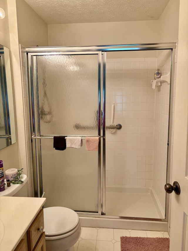 207 S Watchtower Dr Unit 203, Wilder, KY 41076 - bathroom featuring a stall shower, tile patterned floors, vanity, toilet, and a textured ceiling