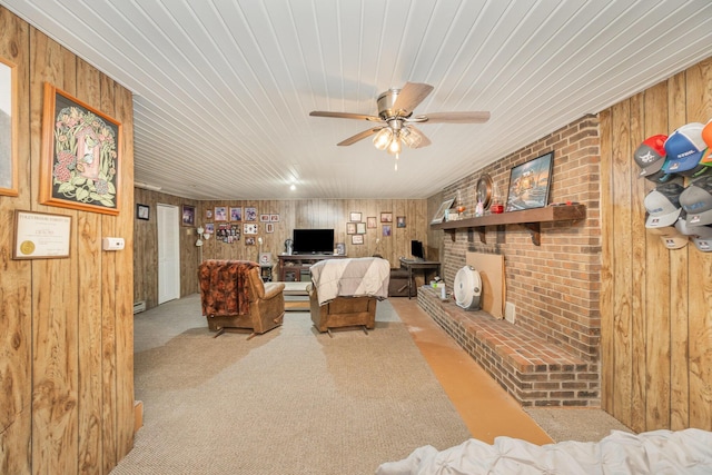 living area with carpet flooring, wood walls, wooden ceiling, and ceiling fan