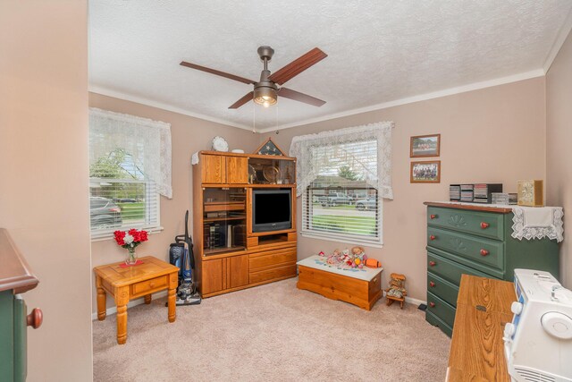 rec room featuring carpet, a textured ceiling, crown molding, and ceiling fan